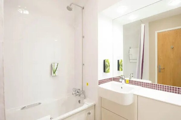 Un baño moderno con bañera, lavamanos y espejo.