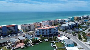 A coastal cityscape with a marina, buildings with balconies, and a clear view of the ocean. - Skyline of Madeira 306 (Madeira Beach)