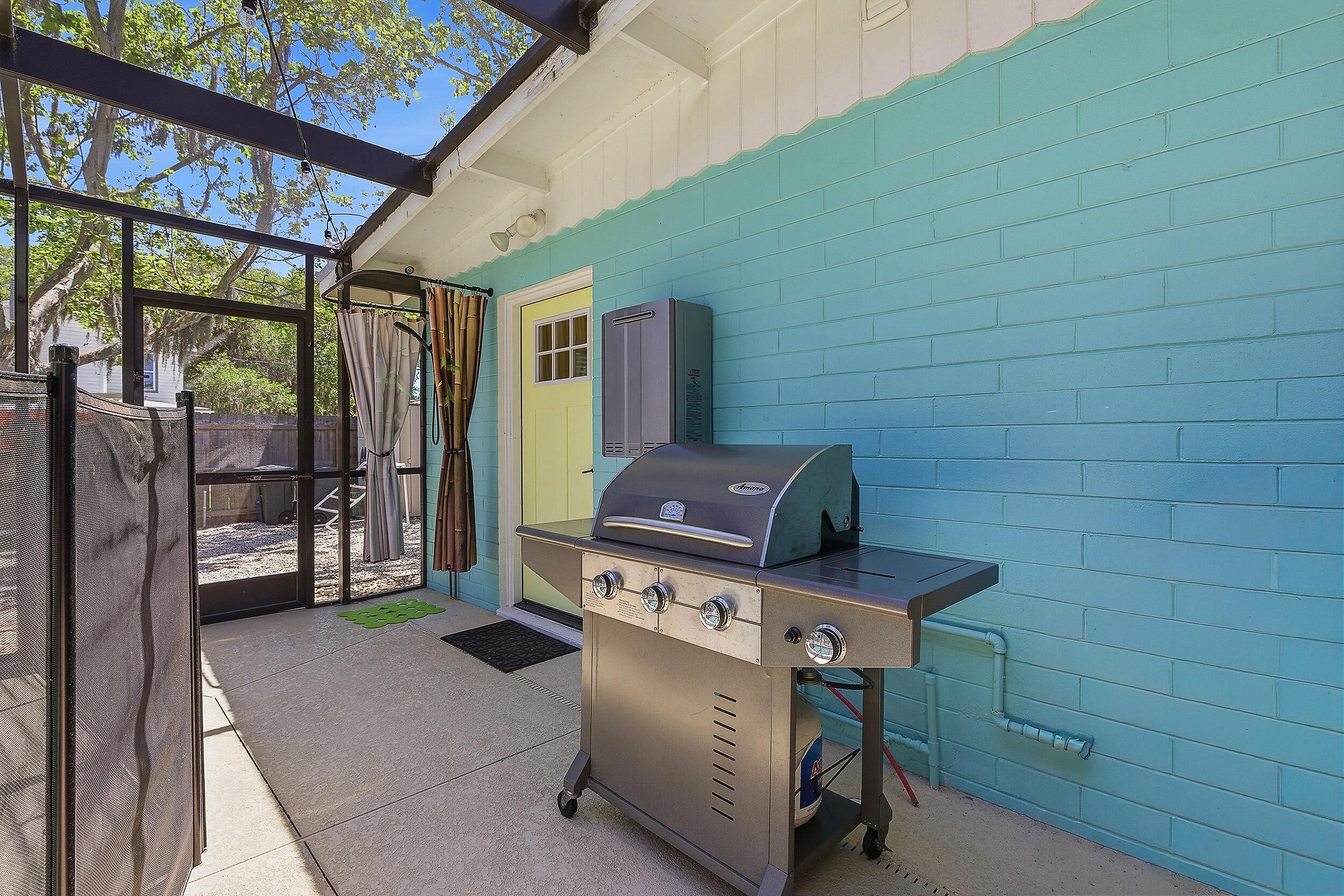 Een terras met een barbecue, een deur en een blauwe muur.