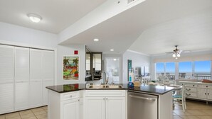 Una cucina con mobili bianchi, un lavello in acciaio inossidabile e una lavastoviglie.