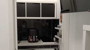 A compact kitchen with a washing machine, a small refrigerator, and a microwave. - The Colors of the Sea - Turquoise Studio Apartment (San Pietro In Bevagna)