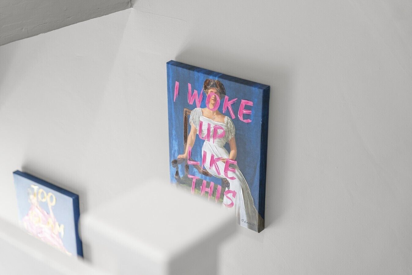 Two framed artworks on a white wall.