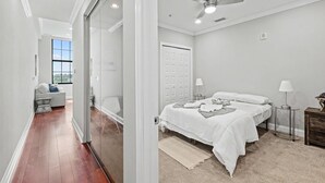 A bedroom with a bed, bedside tables, a ceiling fan, and a view of the outdoors. - Chic Modern 1BD | Northern Libs | Sleeps 2 Stay (Philadelphia)