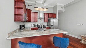 A modern kitchen with marble countertops, stainless steel appliances, and wooden cabinets. - Chic Modern 1BD | Northern Libs | Sleeps 2 Stay (Philadelphia)
