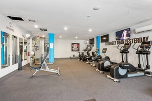 Ein Fitnessstudio mit Cardiogeräten, Gewichten und motivierenden Postern.