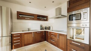 A modern kitchen with wooden cabinets, stainless steel appliances, and a built-in oven. - Villa Morgan – Luxury Villa with Heated Pool near Buje (Buje)