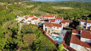 A residential area with houses featuring red-tiled roofs, surrounded by greenery and a clear sky. - Villa Morgan – Luxury Villa with Heated Pool near Buje (Buje)
