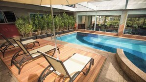 A pool area with lounge chairs and a glass-enclosed room. - #VD1226 | Cyclinn Berrini Chacara Sto Antonio (Berrini)