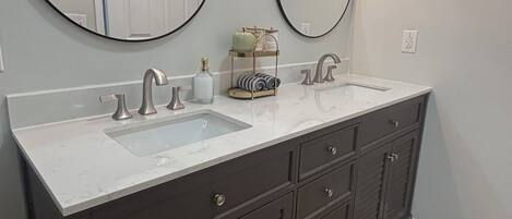 A bathroom with two sinks, dark cabinets, and two wall-mounted mirrors.