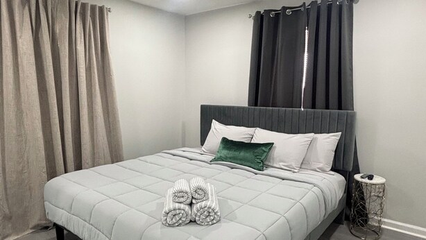 A bedroom with a bed, a ceiling fan, a nightstand, and a small round table. - Delightful 2B/2B modern & Brand new centrally located (Florence)