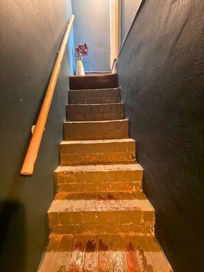 Eine Treppe mit Handlauf und einer Vasen mit Blumen an der Spitze.