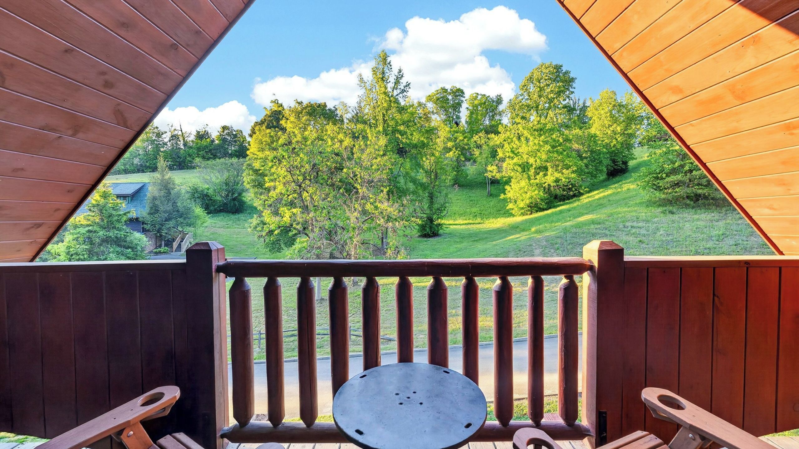 Eine Holzterrasse mit Blick auf eine grüne Landschaft und Bäume.