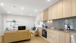 Una cocina moderna con armarios de madera, horno empotrado y lavavajillas.