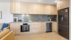 Una cocina moderna con armarios de madera, electrodomésticos de acero inoxidable y lavavajillas integrado.