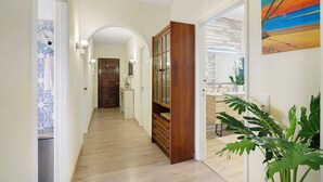 Un passadís amb terra de fusta, un armari de fusta, una porta i una planta.