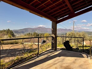 A covered outdoor area with a view of mountains and a town in the distance. - Exceptional stone farmhouse with swimming pool (Les Assions)