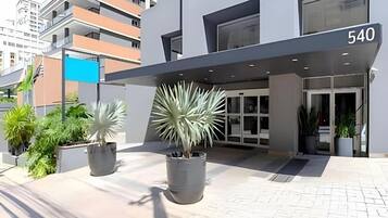 Un edificio moderno con fachada plana, un amplio acceso con puertas de vidrio y el número 540 en el alero.