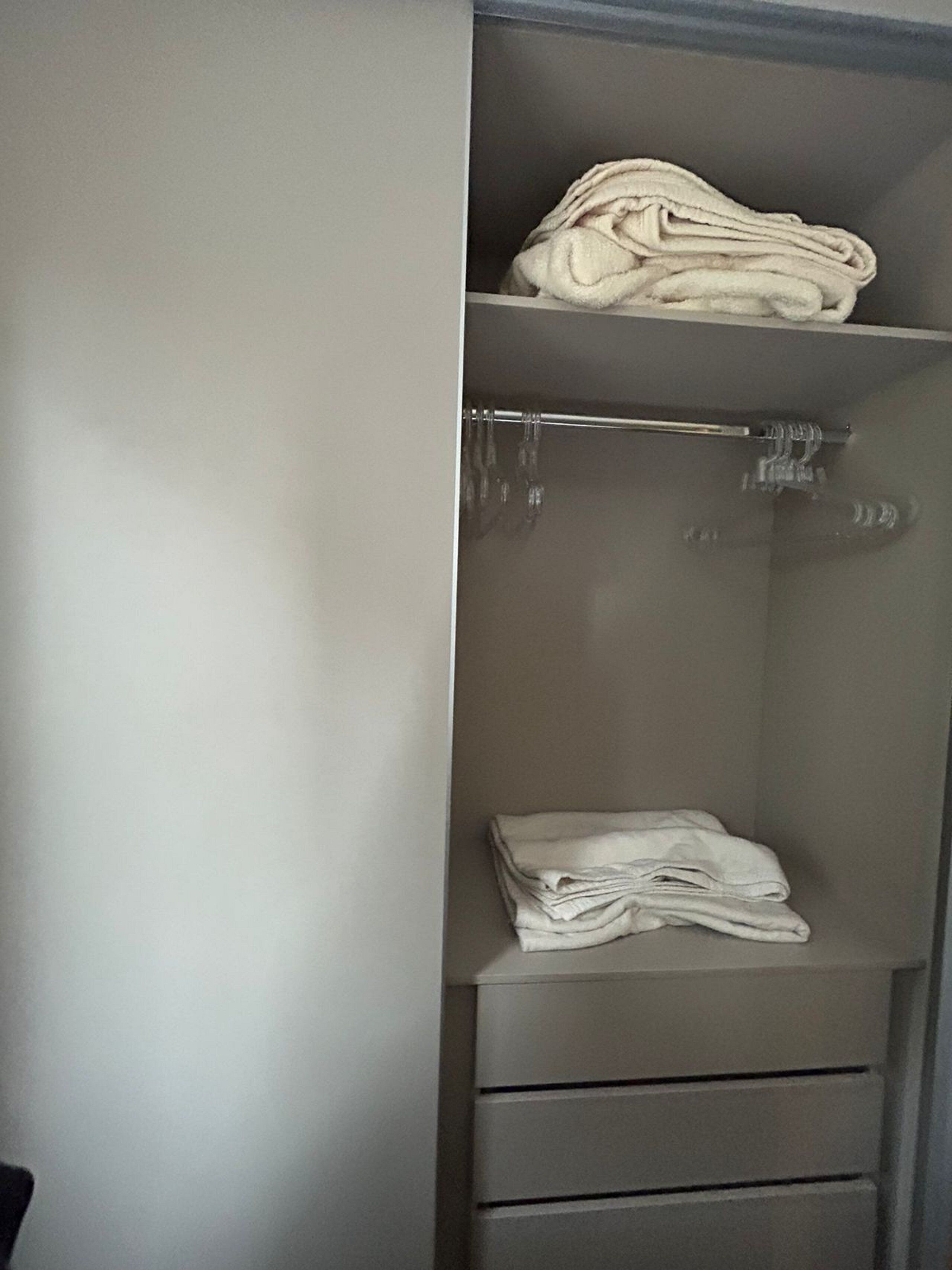 A wardrobe with a hanging rod and two drawers.