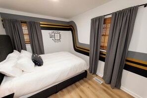A bedroom with a bed, curtains, and a wall decoration. - 5 min to Speedway; Luxury; Game Room; Hot Tub (Indianapolis)