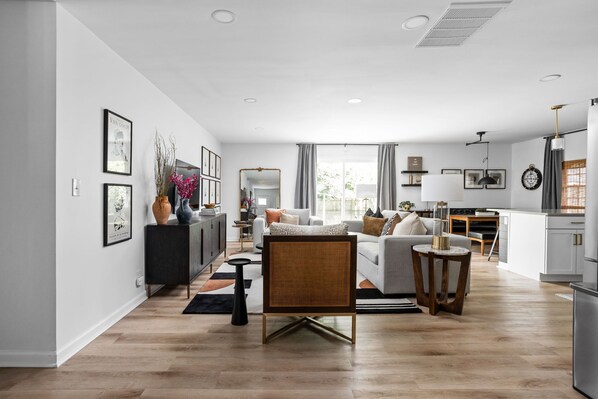 Ein modernes Wohnzimmer mit einer Couch, einem Couchtisch und einem Essbereich mit Tisch und Stühlen.