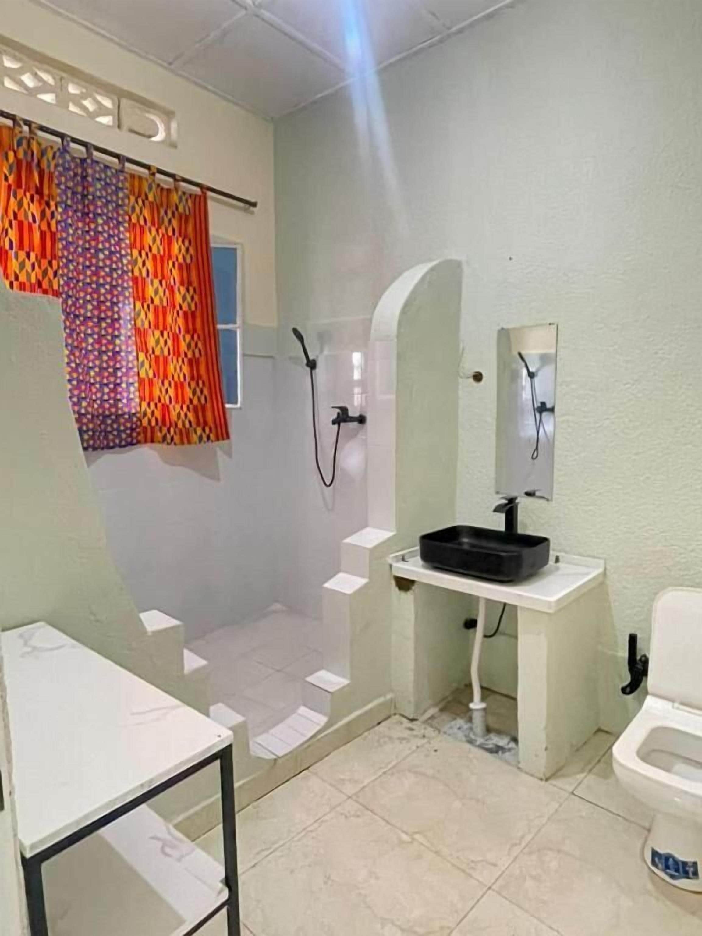 A bathroom with a shower, toilet, and sink.