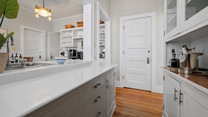 A kitchen with white cabinetry, a wooden countertop, and a hanging light fixture. - Delightful 6-bedroom cottage on charming Lake Carlos in Alexandria, MN (Alexandria)