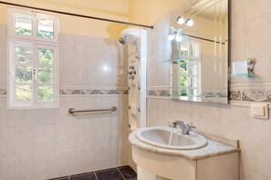 A bathroom with a shower, a sink, a mirror, and a window. - Holiday Home 'Jardim do Sol' with Sea View, Private Garden and Wi-Fi (Lugares)