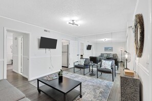 Ein modernes Wohnzimmer mit Flachbildfernseher, Couchtisch und Sofa.