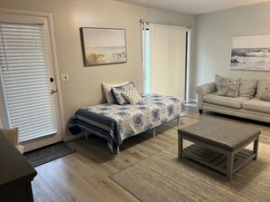 Ein Wohnzimmer mit einem Bett, einem Sofa und einem Couchtisch.
