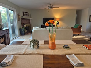 Ein Wohnzimmer mit Kamin, einer Couch, einem Couchtisch mit Dekoration und einem Fernseher.