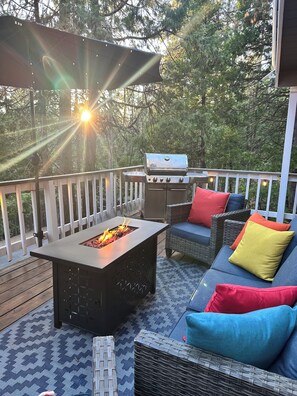 Una terraza con un brasero, mobiliario exterior y una parrilla.
