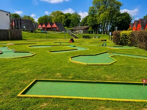 A miniature golf course with green and yellow boundaries, a red flag, and a number 5 sign. - Sea View Coastal Lodge | Pool, Tennis & Family Fun | Walk to Beach | Near Deal (Kingsdown)