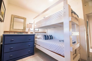 A bunk bed with a white frame, a dresser with drawers, a mirror, and a lamp. - Le Rêve -Beachfront 5BR Luxury Villa w/ Private Pool, Dock & 5 Min to Town (San Pedro)
