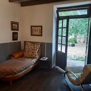A room with a bed, a chair, a small table, and a window with a view of trees. - Quite country retreat, close to villages but very peaceful (Terres-de-Haute-Charente)