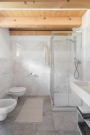 Une salle de bain moderne avec une douche à l’italienne, des toilettes et un lavabo.