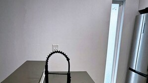 Eine Küche mit einer Spüle aus Edelstahl, einem Wasserhahn und einem Kühlschrank.