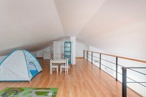Ein geräumiges Dachzimmer mit Zelt, Schreibtisch und Stuhl.