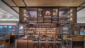 A modern bar area with a central island, bar stools, and a large illuminated sign. - Four Points By Sheraton Guangzhou Changlong Wanbo Business District (Guangzhou)