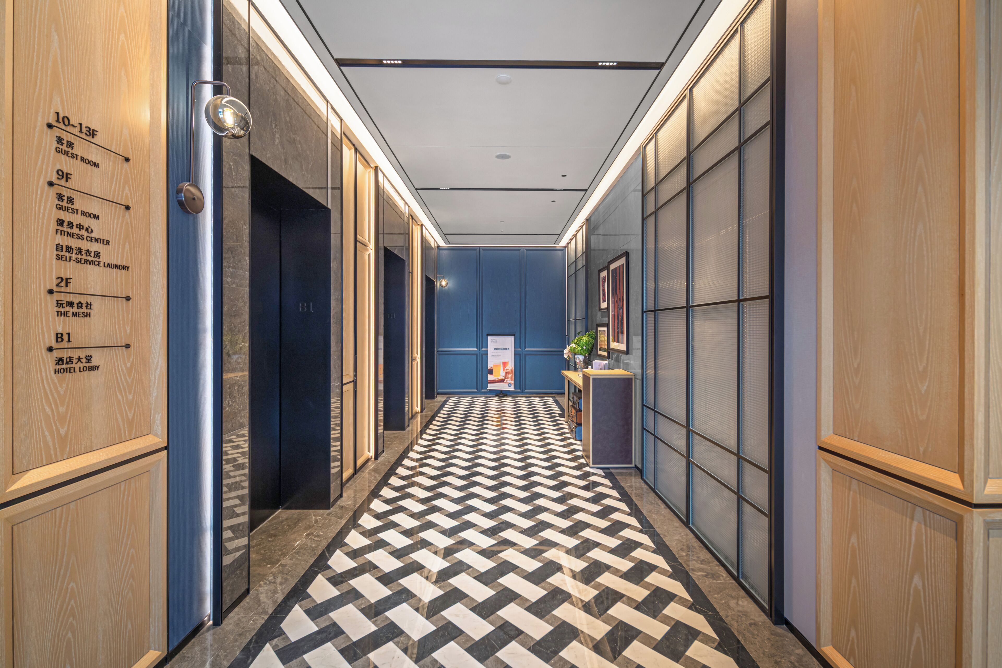 En hotellobby med en incheckningsdisk, en receptionsdisk och skyltar som visar vägen till rummen och de olika faciliteterna.