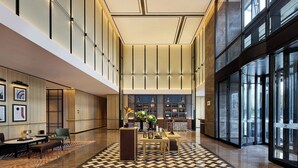 A spacious lobby with a checkered floor, a reception desk, and a seating area with a table and chairs. - Four Points By Sheraton Guangzhou Changlong Wanbo Business District (Guangzhou)