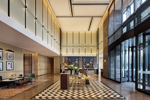 A spacious lobby with a checkered floor, a reception desk, and a seating area with a table and chairs. - Four Points By Sheraton Guangzhou Changlong Wanbo Business District (Guangzhou)