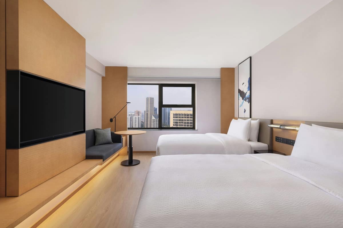 Une chambre d’hôtel avec un grand lit, un canapé, une télévision et une vue sur la ville.