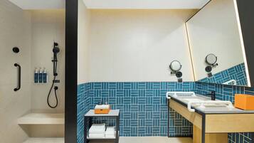 Ein modernes Badezimmer mit Dusche, Waschbecken und Spiegel.