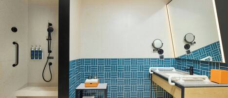 A modern bathroom with a shower, sink, and mirror.
