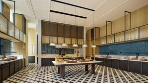 Una cocina moderna con piso de diseño geométrico, una isla central con exhibición de alimentos e iluminación colgante.