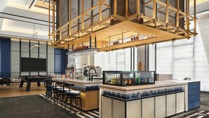 Zona de bar moderna con mesa de billar, taburetes y minibar.