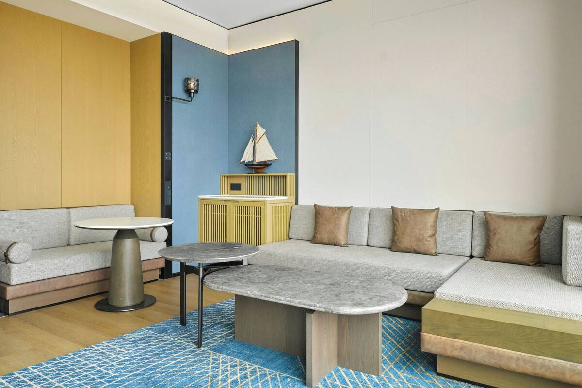 A modern living room with a sectional sofa, a round coffee table, and a small side table.