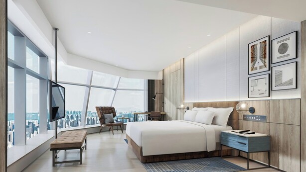 Una habitación de hotel moderna con una cama grande, un escritorio, una silla, un banco y un televisor.