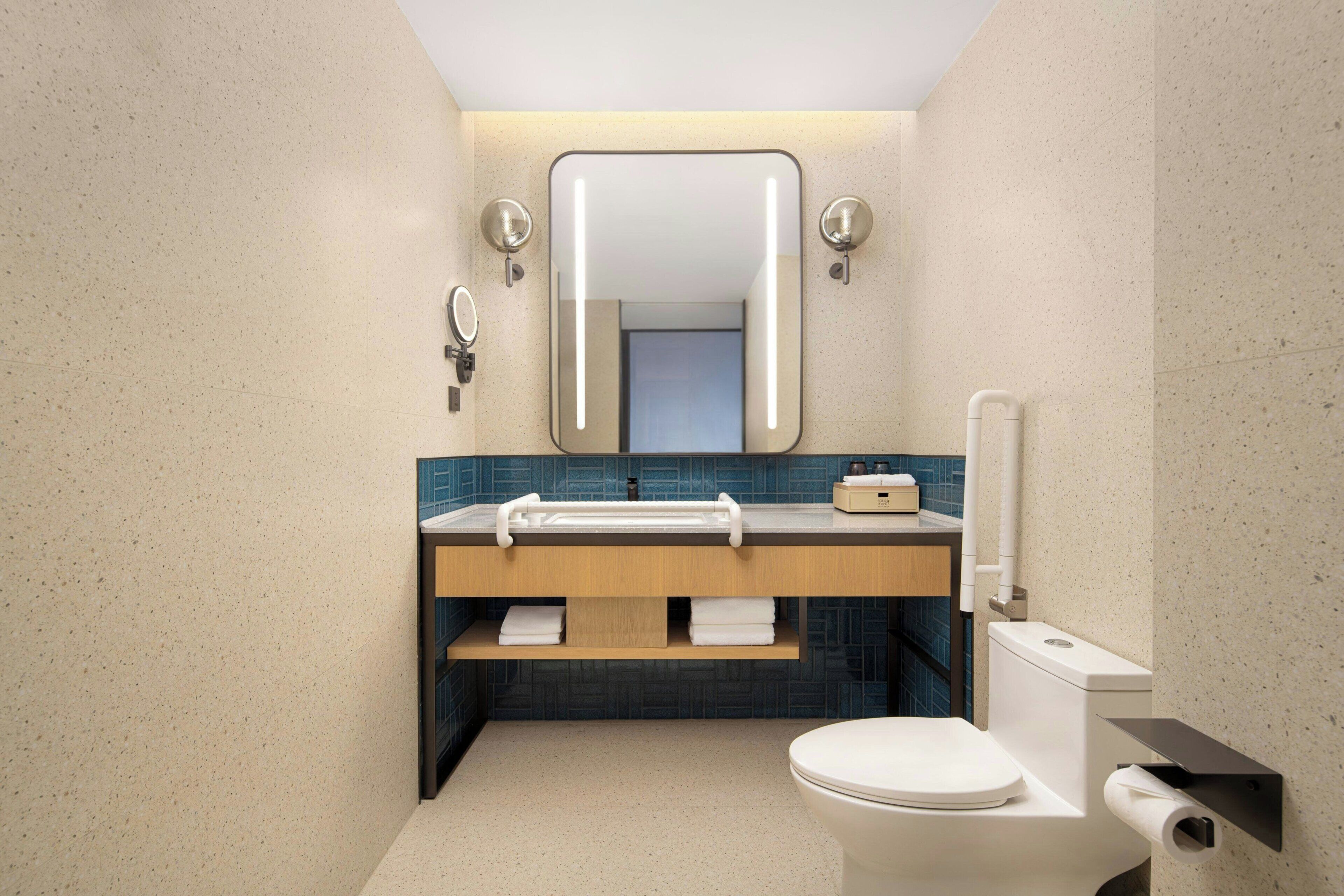 Une salle de bain moderne équipée de toilettes, d’un lavabo et d’un miroir.
