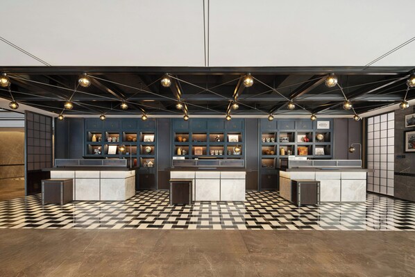 Une cuisine moderne avec un carrelage à motifs, des luminaires suspendus et un îlot central.